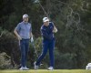 Mackenzie Hughes, of Canada, left, watches Luke List's drive down the second fairway during the final round of the RSM Classic golf tournament, Sunday, Nov. 21, 2021, in St. Simons Island, Ga. (AP Photo/Stephen B. Morton)