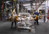 GM workers use human assistance automation to weld vehicle doors at the General Motors assembly plant during the COVID-19 pandemic in Oshawa, Ont., on Friday, March 19, 2021. THE CANADIAN PRESS/Nathan Denette