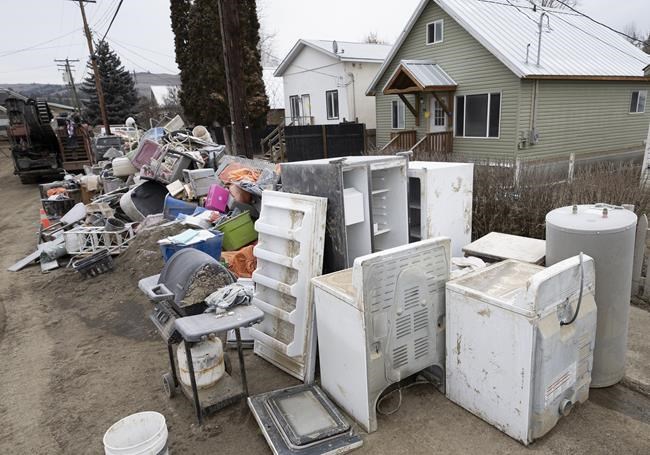 The contents to the insides of homes that were flooded are pictured on the street in downtown Princeton, B.C., Friday, Dec. 3, 2021. Princeton, like many parts of the province, was hit with heavy floods and mudslides over the past couple of weeks causing major devastation. THE CANADIAN PRESS/Jonathan Hayward