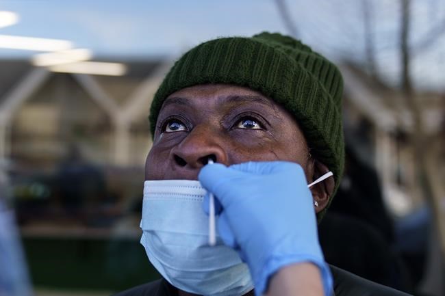 Anthony Richard is swabbed during a COVID-19 test outside Asthenis Pharmacy in Providence, R.I., Tuesday, Dec. 7, 2021. Even as the U.S. reaches a COVID-19 milestone of roughly 200 million fully-vaccinated people, infections and hospitalizations are spiking, including in highly-vaccinated pockets of the country like New England. (AP Photo/David Goldman)