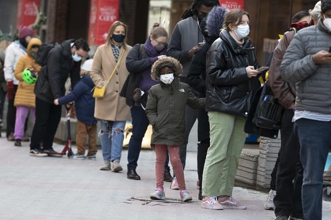 People wait in line outside a COVID-19 walk-in testing site, Sunday, Dec. 5, 2021, in Cambridge, Mass. (AP Photo/Michael Dwyer)