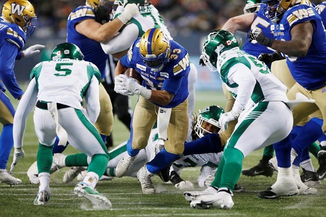 Winnipeg Blue Bombers' Andrew Harris (33) runs for the first down against the Saskatchewan Roughriders during second half CFL Western final football action in Winnipeg, Sunday, Dec. 5, 2021. THE CANADIAN PRESS/John Woods