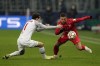 Salzburg's Brenden Aaronson, left, challenges with Sevilla's Papu Gomez during the Champions League Group G soccer match between RB Salzburg and Sevilla at the Red Bull Arena in Salzburg, Austria, Wednesday, Dec. 8, 2021. (AP Photo/Lisa Leutner)