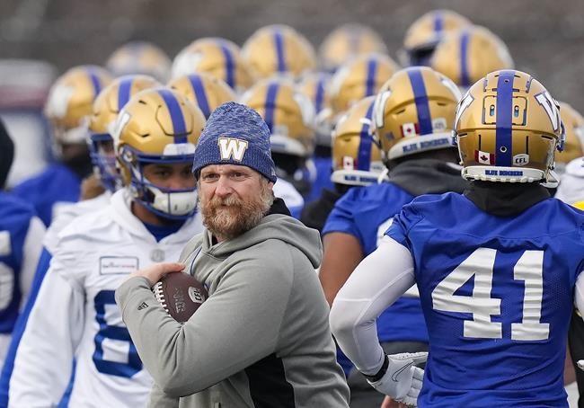 Winnipeg Blue Bombers head coach Mike O'Shea, front left, walks with the football during practice ahead of the 108th CFL Grey Cup against the Hamilton Tiger-Cats in Hamilton, Ont., on Wednesday, December 8, 2021. THE CANADIAN PRESS/Nathan Denette