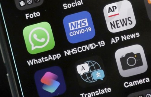 A view of an iphone showing the new NHS COVID-19 mobile phone application after the app went live on Thursday morning in London, Thursday, Sept. 24, 2020. A new report group says digital contact tracing apps, artificial intelligence and other tech tools that European governments rolled out to combat COVID-19 failed to play a key role in solving the pandemic and now threaten to make such monitoring widely accepted. The nonprofit research group AlgorithmWatch said Thursday, Dec. 9, 2021 that the health surveillance technologies many countries deployed were often adopted without enough transparency, safeguards or democratic debate. (AP Photo/Frank Augstein, File)