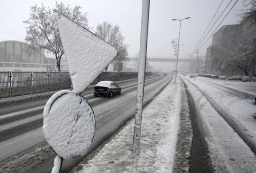 Cars on the street during snow storm in Belgrade, Serbia, Sunday, Dec. 12, 2021. Meteorologists predict heavy snowfall and sub zero temperatures in the Western Balkans throughout the week. (AP Photo/Darko Vojinovic)