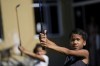 CORRECTS CADDIE'S SURNAME - Children learn the basics of golf from caddie Marcelo Modesto on the grounds of the Nusacquilombo cultural center in Cidade de Deus or City of God favela, in Rio de Janeiro, Brazil, Thursday, Dec. 9, 2021. Modesto from one of Rio's poorest neighborhoods works at one of the seaside city's most exclusive golf courses, earning a comfortable living guiding wealthy patrons around the fairways and greens of the course. Now he is sharing his golf skills with kids from his favela. (AP Photo/Silvia Izquierdo)