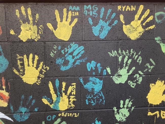 Some of the handprints of people recovering from drug addiction are seen on Dec. 9, 2021, on a wall in the parking lot of Provoking Hope, an addiction recovery center in McMinnville, Ore. Along with the handprints are the dates when they became