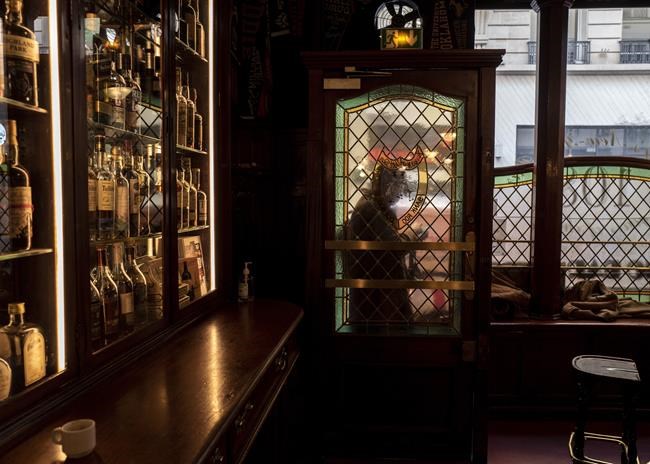 A man stands at the door of Harry's Bar in Paris, Friday, Dec. 10, 2021. Harry's Bar in Paris is celebrating the 100th birthday of the Bloody Mary, the vodka-tomato juice cocktail believed to have been invented in the iconic bar in 1921. The centenary events this week come as a welcome respite from winter gloom and spreading worries about the omicron virus variant. (AP Photo/Rafael Yaghobzadeh)