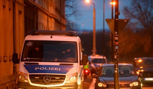 A police car is seen in the Pieschen district during a raid after threats against Saxony's Prime Minister Kretschmer, in Dresden, Germany, early Wednesday, Dec. 15, 2021. Police in eastern Germany are carried out raids in an investigation of alleged threats to kill a state governor and others by opponents of coronavirus restrictions and vaccinations. They said that five properties in Dresden and one in a nearby town were being searched on Wednesday in an investigation of suspected preparations for a serious act of violence. (Robert Michael/dpa via AP)