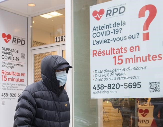 A man walks by a COVID-19 rapid testing business in Montreal, Saturday, Dec. 4, 2021. THE CANADIAN PRESS/Graham Hughes