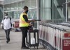 A man uses a sanitizer spray to wash down luggage carts at Toronto's Pearson International Airport  in Toronto on Tuesday, June 23, 2020. Prime Minister Justin Trudeau says people will have to be careful as they finalize their Christmas plans this year, now that the highly transmissible Omicron variant is spreading through Canada. THE CANADIAN PRESS/Nathan Denette