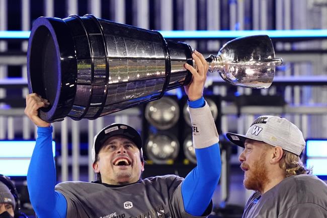 Winnipeg Blue Bombers quarterback Zach Collaros (8) hoists the Grey Cup as he celebrates defeating the Hamilton Tiger-Cats in the 108th CFL Grey Cup in Hamilton, Ont., on Sunday, December 12, 2021. THE CANADIAN PRESS/Frank Gunn
