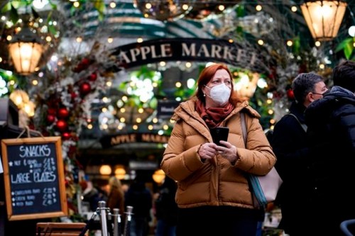 A woman wears a face mask as she walks in Covent Garden market, in London, Thursday, Dec. 16, 2021. The U.K. recorded the highest number of confirmed new COVID-19 infections Wednesday since the pandemic began, and England's chief medical officer warned the situation is likely to get worse as the omicron variant drives a new wave of illness during the Christmas holidays. The U.K. recorded 78,610 new infections on Wednesday, 16% higher than the previous record set in January. (AP Photo/Alberto Pezzali)