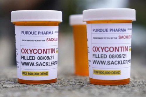 FILE - In this Aug. 9, 2021, file photo, fake pill bottles with messages about OxyContin maker Purdue Pharma are displayed during a protest outside the courthouse where the bankruptcy of the company is taking place in White Plains, N.Y. A federal judge on Thursday, Dec. 16, 2021, has rejected OxyContin maker Purdue Pharma’s bankruptcy settlement of thousands of lawsuits over the opioid epidemic because of a provision that would protect members of the Sackler family from facing litigation of their own. (AP Photo/Seth Wenig, File)