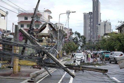 Toppled electrical posts lie along a street in Cebu city, central Philippines caused by Typhoon Rai on Friday, Dec. 17, 2021. A powerful typhoon slammed into the southeastern Philippines on Thursday, toppling trees, ripping tin roofs and knocking down power as it blew across island provinces where nearly 100,000 people have been evacuated. (AP Photo/Jay Labra)