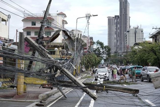 Toppled electrical posts lie along a street in Cebu city, central Philippines caused by Typhoon Rai on Friday, Dec. 17, 2021. A powerful typhoon slammed into the southeastern Philippines on Thursday, toppling trees, ripping tin roofs and knocking down power as it blew across island provinces where nearly 100,000 people have been evacuated. (AP Photo/Jay Labra)