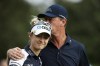 Petr Korda, right, kisses his daughter Nelly Korda while walking off the first tee during the second round of the PNC Championship golf tournament Sunday, Dec. 19, 2021, in Orlando, Fla. (AP Photo/Scott Audette)