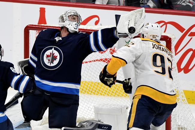 Winnipeg Jets' goaltender Connor Hellebuyck (37) makes a save on Nashville Predators’ Ryan Johansen (92) during the third period of NHL action in Winnipeg on Saturday, October 23, 2021. THE CANADIAN PRESS/Fred Greenslade