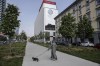 FILE - A woman walks a dog near the Inter Milan headquarters in Milan, Italy, on April 19, 2021. Serie A champion Inter Milan is the latest club to have its offices raided by the finance police as part of the ongoing investigation into false accounting. Authorities raided the offices of Juventus last month to gather information on player transfers and agent dealings between 2019 and this year. (AP Photo/Luca Bruno, File)