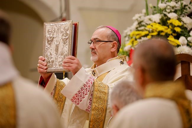 The acting Latin Patriarch of Jerusalem Pierbattista Pizzaballa leads a Christmas midnight mass at Saint Catherine's Church, in the Church of the Nativity, in Bethlehem, West Bank Saturday, Dec. 25, 2021. (Mussa Qawasma/Pool Photo via AP)