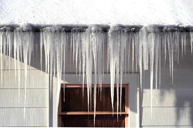 Long icicles hang from a house where nearly a foot of snow fell over the weekend, Monday, Dec. 27, 2021, in Bellingham, Wash. Sunday's snow showers blew into the Pacific Northwest from the Gulf of Alaska, dumping up to 6 inches across the Seattle area. More than a foot was reported near Port Angeles across the Puget Sound on the Olympic Peninsula. (AP Photo/Elaine Thompson)