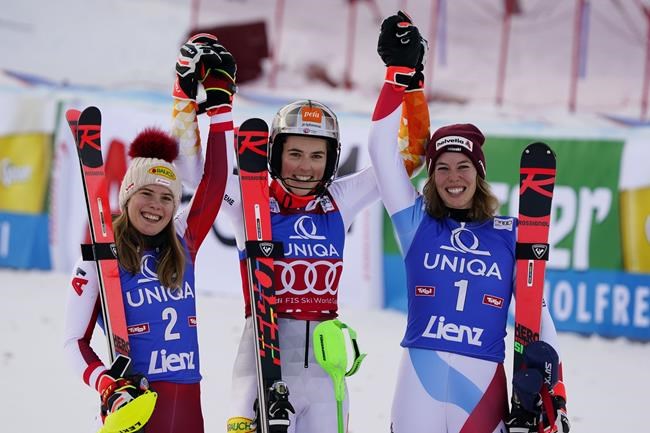 Winner, Slovakia's Petra Vlhova , center, is flanked by second place Austria's Katharina Liensberger , let and third place Switzerland's Michelle Gisin on the podium after an alpine ski women's World Cup slalom race, in Lienz, Austria, Wednesday, Dec. 29, 2021. (AP Photo/Marco Tacca)