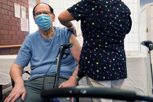 FILE - Marvin Marcus, 79, a resident at the Hebrew Home at Riverdale, receives a COVID-19 booster shot in New York, Sept. 27, 2021. Federal health officials call on nursing homes to redouble efforts to administer COVID-19 booster shots to residents and staff amid sharply rising cases among staff and lagging rates of booster vaccination. (AP Photo/Seth Wenig, File)