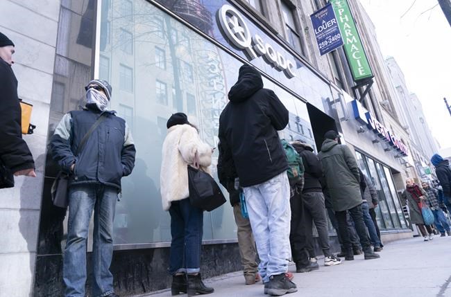 Consumers line up at a Quebec cannabis store in Montreal on Wednesday, March 18, 2020. Quebec will require people to show proof of vaccination against COVID-19 to enter liquor and cannabis stores starting Jan. 18. THE CANADIAN PRESS/Paul Chiasson