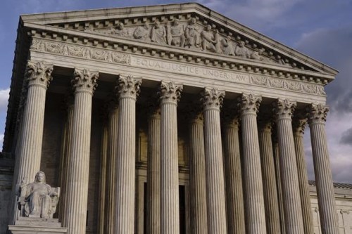 FILE - The Supreme Court is seen at dusk in Washington, Oct. 22, 2021. The Supreme Court will hear oral arguments Jan. 7, 2022, on challenges to whether the Biden administration can order millions of workers at private companies and health care employees be vaccinated for COVID-19. Until the court rules, millions of workers face a patchwork of requirements depending on where they live. (AP Photo/J. Scott Applewhite, File)