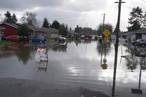 Floodwaters cover a residential street near Centralia, Wash., Friday, Jan. 7, 2022. Rain and snow continued to fall across the Pacific Northwest Friday, causing flooding and concerns about avalanche danger in the mountains. (AP Photo/Ted S. Warren)