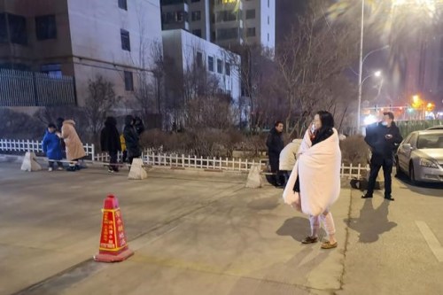 In this photo released by China's Xinhua News Agency, people stand on the street after an earthquake in Xining in northwestern China's Qinghai Province, early Saturday, Jan. 8, 2022. An overnight earthquake shook a sparsely populated area in western China early Saturday, authorities said. There were no immediate reports of injuries. (Wang Bo/Xinhua via AP)