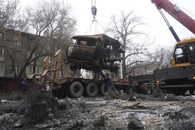 A crane loads a military truck, which was burned during clashes onto the platform in Almaty, Kazakhstan, Sunday, Jan. 9, 2022. Kazakhstan's health ministry says at least 164 people have been killed in protests that have rocked the country over the past week. President Kassym-Jomart Tokayev's office said Sunday that order has stabilized in the country and that authorities have regained control of administrative buildings that were occupied by protesters, some of which were set on fire. (Vladimir Tretyakov/NUR.KZ via AP)