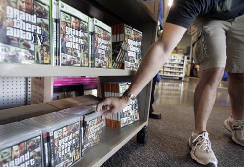 FILE - A Best Buy customer takes a copy of the game Grand Theft Auto IV in Mountain View, Calif., Tuesday, April 29, 2008. Take-Two Interactive, maker of Grand Theft Auto and Red Dead Redemption, is buying Zynga, maker of FarmVille and Words With Friends, in a cash-and-stock deal with an enterprise value of about $12.7 billion. Take-Two said Monday, Jan. 10, 2022, it anticipates $100 million in annual cost savings.(AP Photo/Paul Sakuma, File)