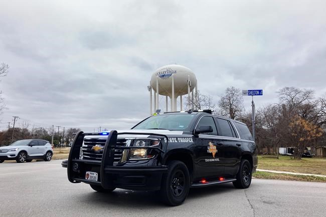 A Texas state trooper blocks traffic on a road leading to a Colleyville, Texas, synagogue where a man apparently took hostages, Saturday, Jan. 15, 2022. (AP Photo/Jake Bleiberg)