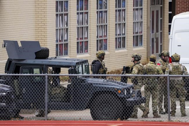 Law enforcement teams stage near Congregation Beth Israel while conducting SWAT operations in the 6100 block of Pleasant Run Road on Saturday, Jan. 15, 2022, in Colleyville, Texas. Authorities said a man took hostages Saturday during services at the Texas synagogue. (Smiley N. Pool/The Dallas Morning News via AP)
