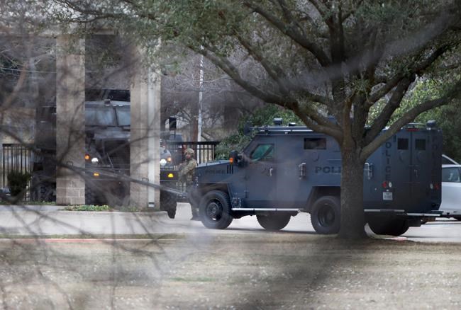 Law enforcement teams stage near Congregation Beth Israel while conducting SWAT operations in Colleyville, Texas on Saturday afternoon, Jan. 15, 2022. Authorities said a man took hostages Saturday during services at the synagogue where the suspect could be heard ranting in a livestream and demanding the release of a Pakistani neuroscientist who was convicted of trying to kill U.S. Army officers in Afghanistan. (Lynda M. Gonzalez/The Dallas Morning News via AP)