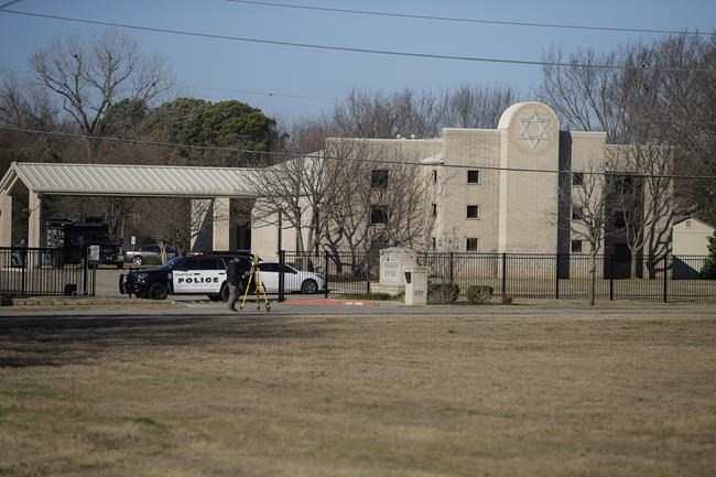 Law enforcement process the scene in front of the Congregation Beth Israel synagogue, Sunday, Jan. 16, 2022, in Colleyville, Texas. A man held hostages for more than 10 hours Saturday inside the temple. The hostages were able to escape and the hostage taker was killed. FBI Special Agent in Charge Matt DeSarno said a team would investigate