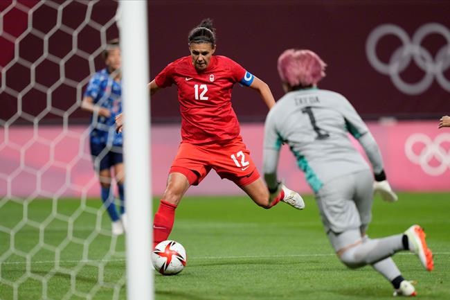 Canada's Christine Sinclair (12) scores a goal against Japan at the 2020 Summer Olympics, Wednesday, July 21, 2021, in Sapporo, Japan. The world governing body of soccer honoured Canada captain Christine Sinclair on Monday for her record goal-scoring. THE CANADIAN PRESS/AP-Silvia Izquierdo