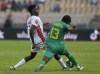 Guinea's Ilaix Moriba, left, is challenged by Zimbabwe's habani Kamusoko, during the African Cup of Nations 2022 group B soccer match between Zimbabwe and Guinea at the Ahmadou Ahidjo stadium in Yaounde, Cameroon, Tuesday, Jan. 18, 2022. (AP Photo/Themba Hadebe)