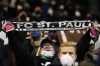 A St. Pauli supporter holds up a scarf as he cheers prior the German Soccer Cup round of 16 soccer match between FC St. Pauli and Borussia Dortmund in Hamburg, Germany, Tuesday, Jan. 18, 2022. (AP Photo/Martin Meissner)