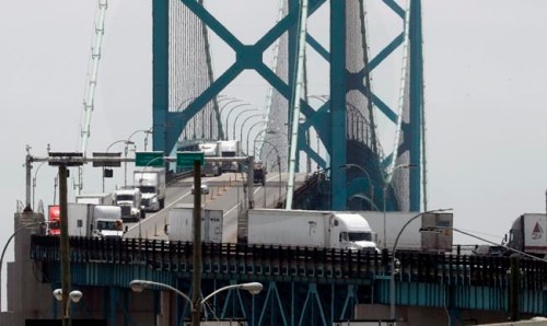 In this Tuesday, June 12, 2018, photo, trucks cross the Ambassador Bridge from Windsor, Ont. into Detroit. Turmoil and confusion last week over whether truckers would remain exempt from the COVID-19 vaccine mandate followed misinterpretations of regulations by both the Public Health Agency of Canada and the Canada Border Services Agency. THE CANADIAN PRESS/AP, Paul Sancya