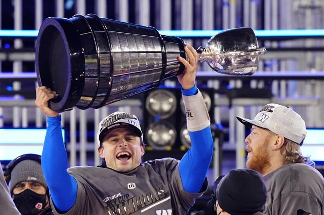 Winnipeg Blue Bombers quarterback Zach Collaros (8) hoists the Grey Cup as he celebrates defeating the Hamilton Tiger-Cats in the 108th CFL Grey Cup in Hamilton, Ont., on Sunday, December 12, 2021. THE CANADIAN PRESS/Frank Gunn