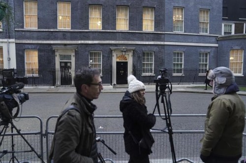 Members of the media gather outside 10 Downing Street, as Britain's Prime Minister Boris Johnson faces fresh allegations of breaking coronavirus rules after Downing Street admitted he had a birthday celebration inside No 10 during the first lockdown, in London, Tuesday, Jan. 25, 2022. (Stefan Rousseau/PA via AP)