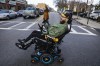 Will Good operates his wheelchair down a street in the South Boston neighborhood of Boston, Jan. 20, 2022. Good, who was left a quadriplegic when his Uber vehicle crashed last year, is seeking $63 million in damages in a negligence lawsuit that was filed against the ride-hailing platform. (Erin Clark/The Boston Globe via AP)