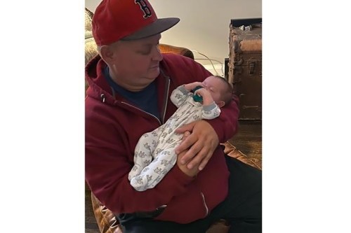 This undated image provided by Todd Culotta shows Chuck Culotta holding his nephew, Kingston, Culotta. The death toll continues to mount from the latest surge of COVID-19. Among those who died was 50-year-old Chuck Culotta. The Delaware man started feeling ill just before Christmas, tested positive Christmas Day, and his condition took a dramatic turn on New Year's Eve. His heart stopped beating at a hospital and he died within hours. His brother, Todd, said Chuck was an outgoing man who made friends easily. (Todd Culotta via AP)