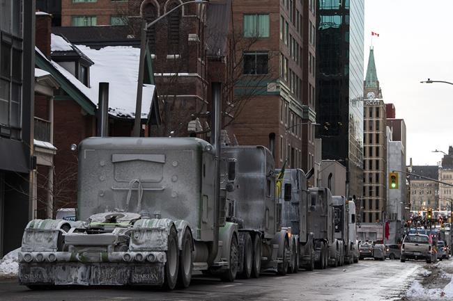 Trucks are parked on Metcalfe Street as a rally against COVID-19 restrictions, which began as a cross-country convoy protesting a federal vaccine mandate for truckers, continues in Ottawa, on Sunday, Jan. 30, 2022. THE CANADIAN PRESS/Justin Tang