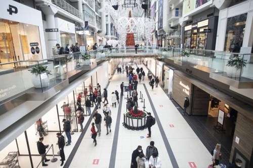 Shoppers line up at stores at a Toronto mall on Friday, Dec. 31, 2021. Canada's most populous provinces have eased some COVID-19 restrictions Monday, while students head back to classrooms in two Maritime provinces.&nbsp;THE CANADIAN PRESS/Chris Young