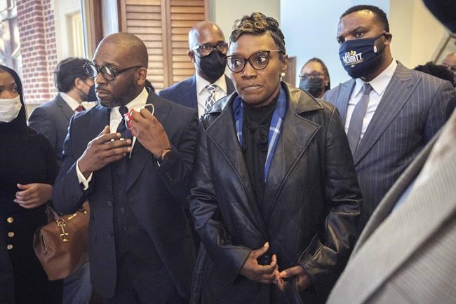 FILE - Ahmaud Arbery's mother Wanda Cooper-Jones, center, is surrounded by supporters after Superior Court Judge Timothy Walmsley sentenced Greg McMichael, his son, Travis McMichael, and a neighbor, William