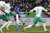 Japan's Takumi Minamino, center, shoots to score a goal during the World Cup 2022 group B qualifying soccer match between Japan and Saudi Arabia at Saitama Stadium 2002 in Saitama, north of Tokyo, Tuesday, Feb. 1, 2022, . (AP Photo/Eugene Hoshiko)